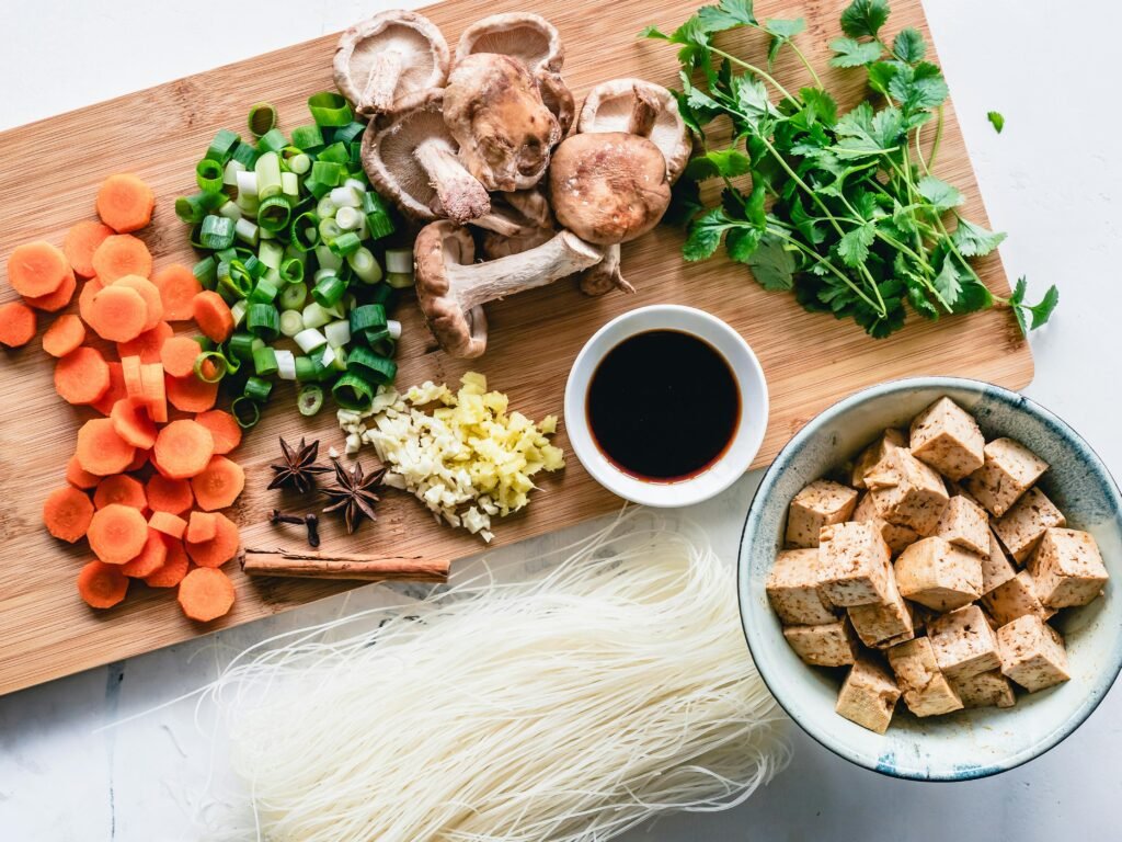 Vibrant assortment of fresh vegetables, herbs, and tofu for an authentic Asian meal preparation.